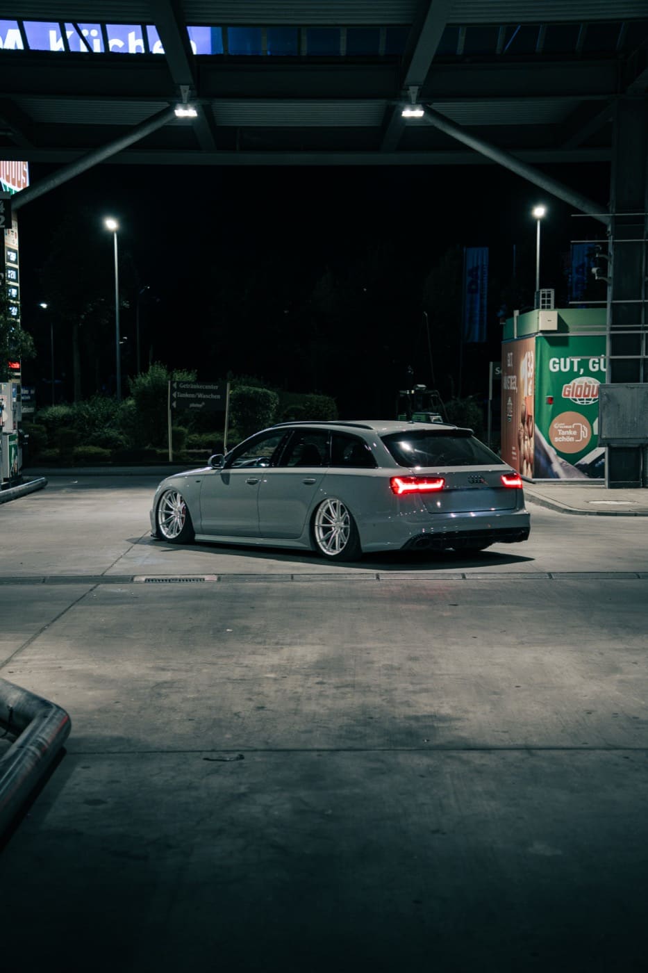 Audi A6 bei Nacht an einer Tankstelle