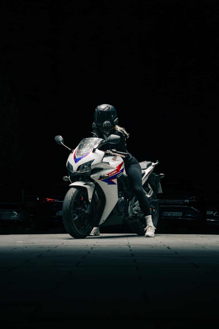 Motorrad mit Fahrerin bei Nacht